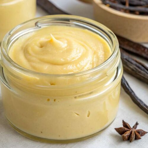 reamy homemade vanilla paste in a glass jar with vanilla beans and star anise on a linen napkin